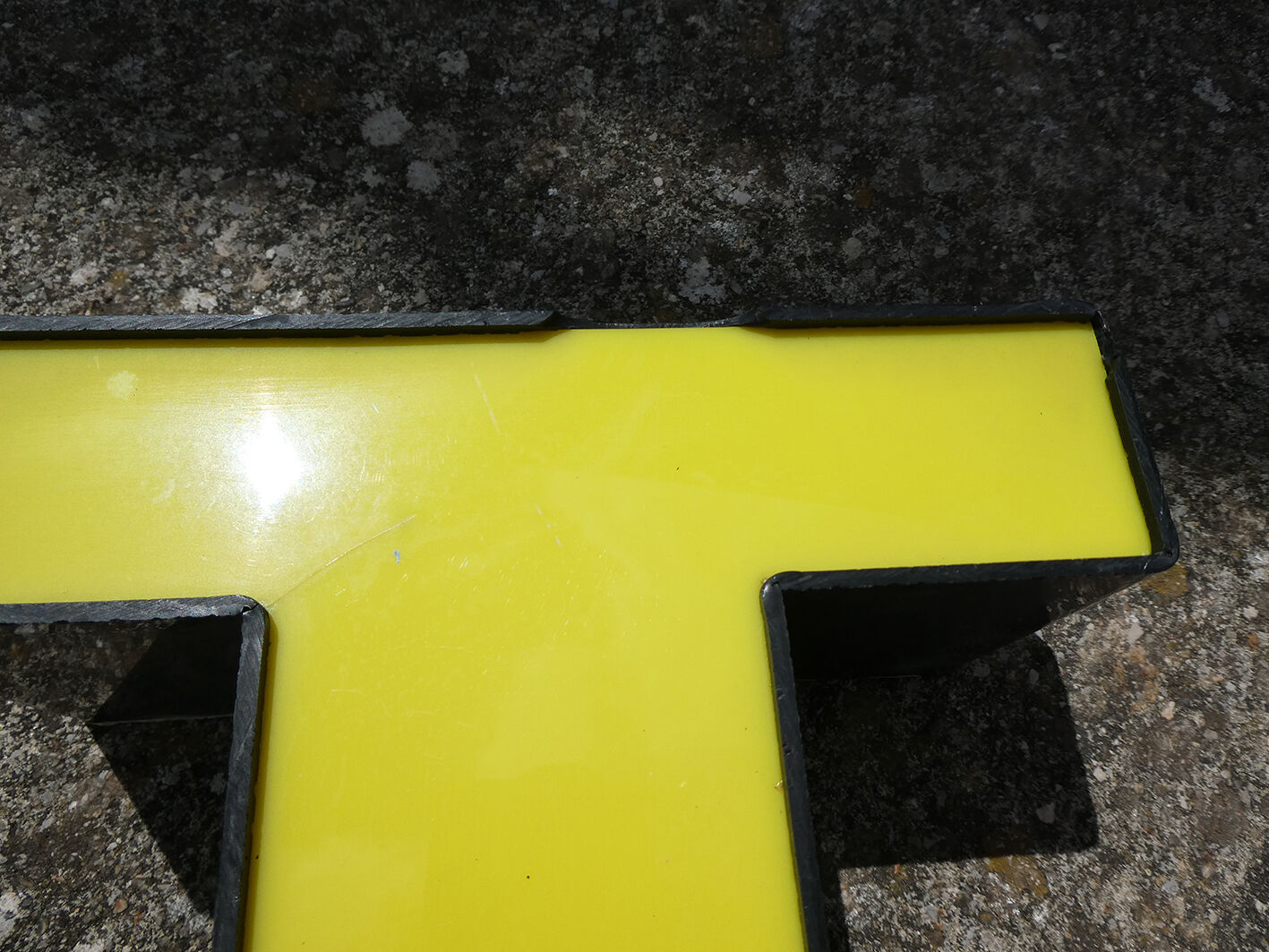 Lettre T d'enseigne industrielle jaune et noire
