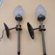 Pair of brass torch wall lights with globe flame.