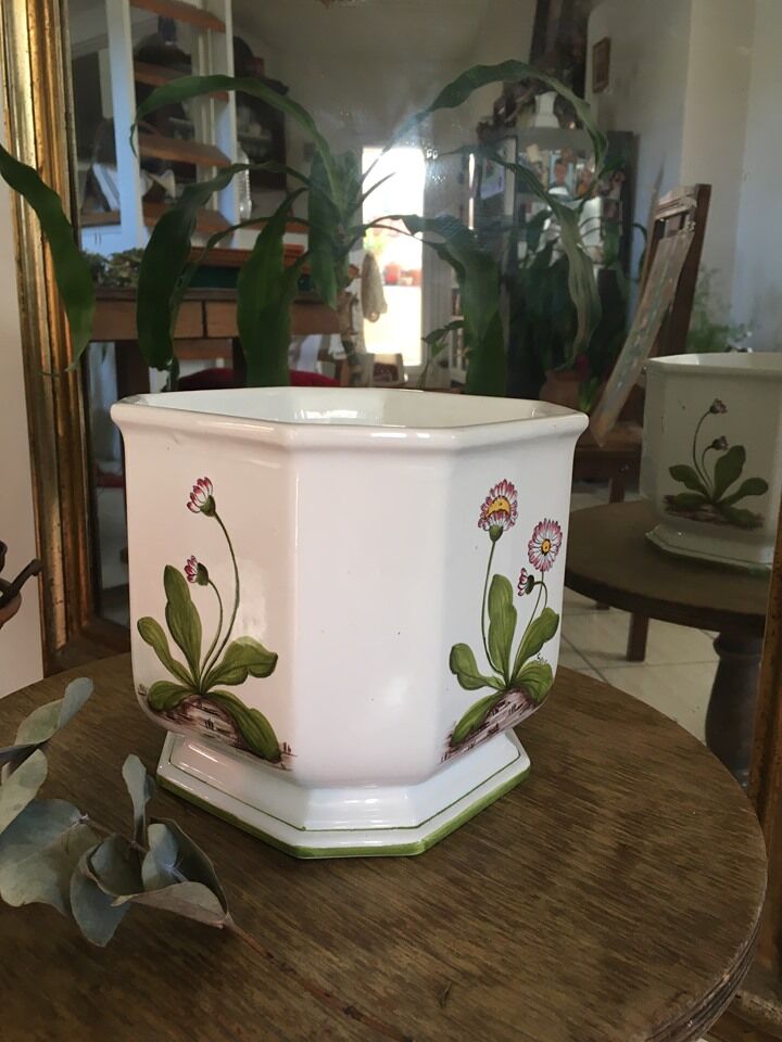 Cover - white ceramic pot decorated with stylized flowers.