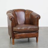 Fauteuil club en cuir de mouton foncé avec passepoil noir