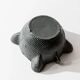 Vintage ceramic ashtray from the 1960s, black, hand-sculpted texture, organic shape.