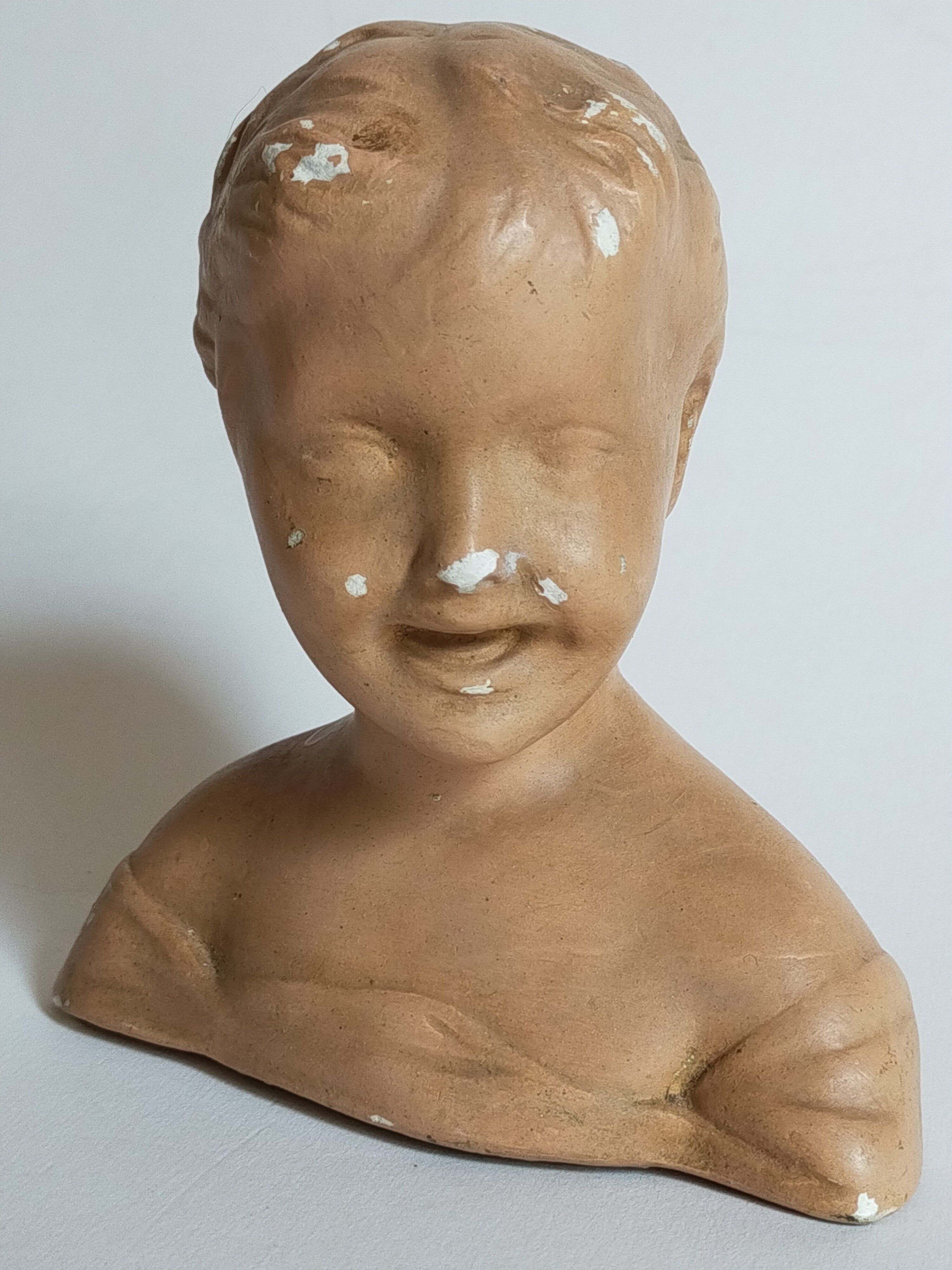 Bust of a small child in ancient plaster
