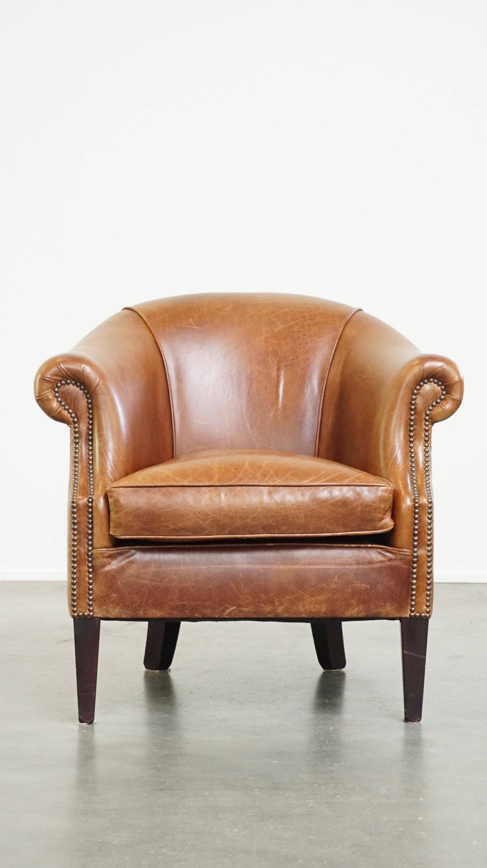 Very comfortable, elegant leather club armchair with a removable seat cushion and timeless design