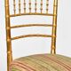 Pair of golden wood chairs in a bamboo style.