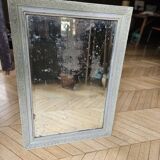 Old mirror with light green contours with mauve shades
