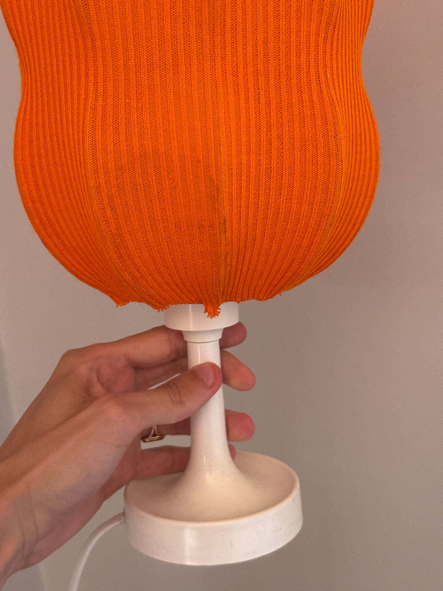Lamp with a plastic base and a coloured fabric shade in Mid Century style.