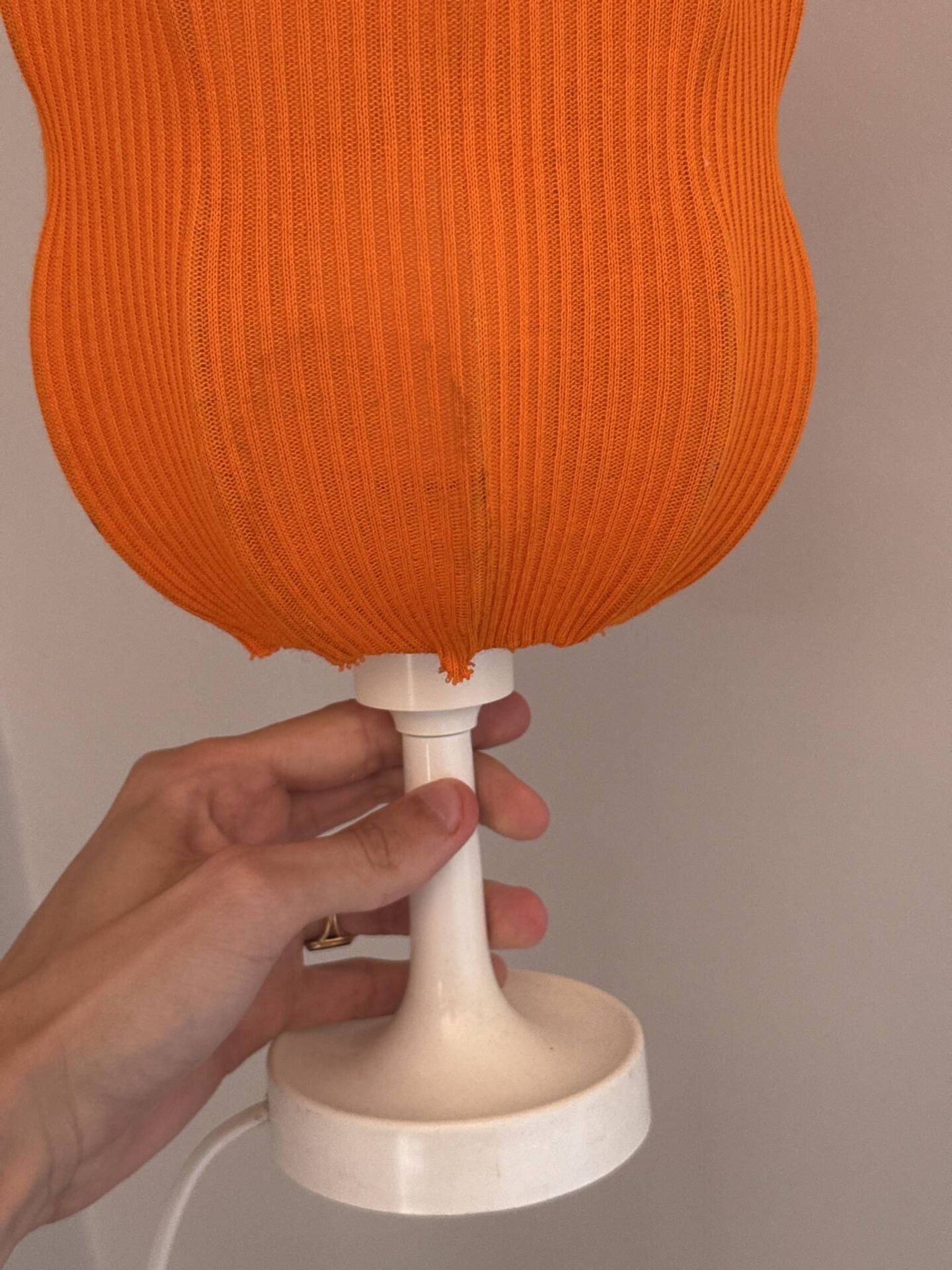 Lamp with a plastic base and a coloured fabric shade in Mid Century style.