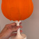 Lamp with a plastic base and a coloured fabric shade in Mid Century style.