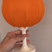 Lamp with a plastic base and a coloured fabric shade in Mid Century style.
