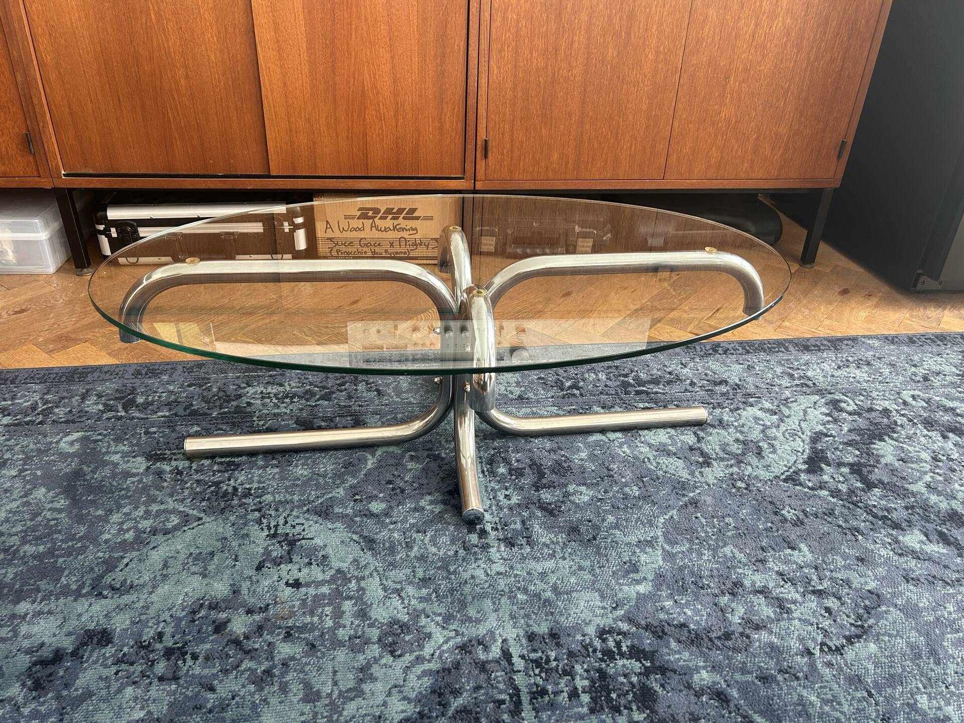 Oval glass coffee table with chrome legs, vintage 70s design.