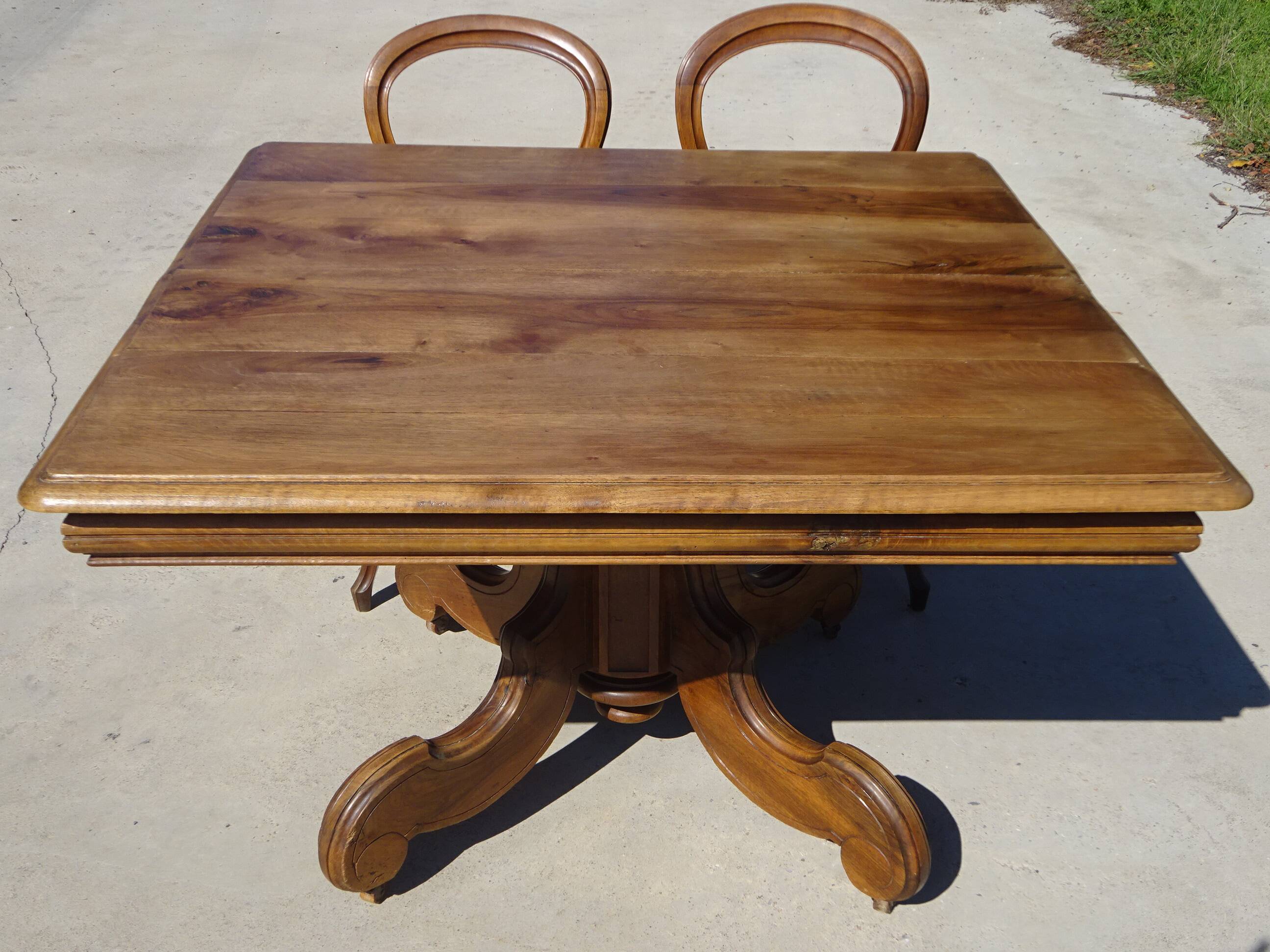 Old walnut table with a central leg.