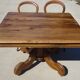 Old walnut table with a central leg.