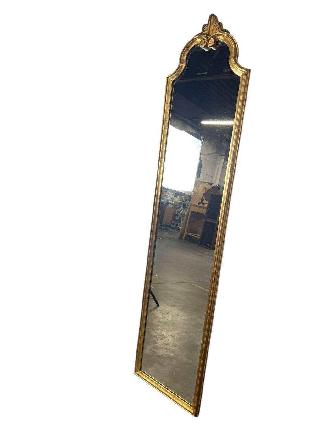 Narrow and tall antique mirror, adorned with golden patterns.