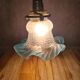 An antique lampshade in frosted glass with delicate blue edges.