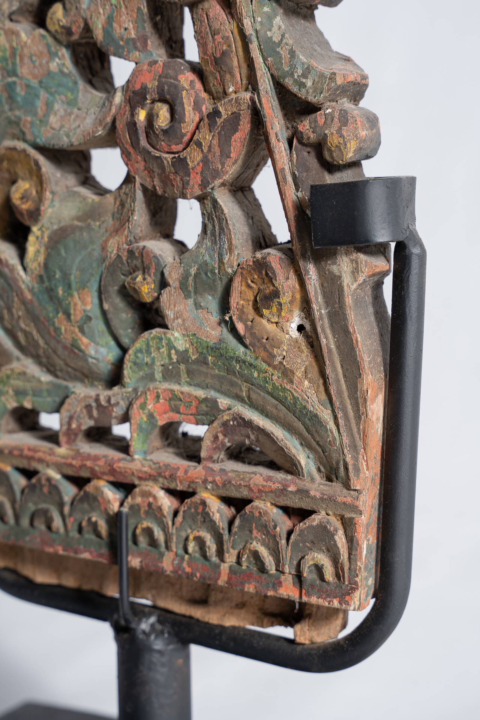 Indonesian construction element in carved wood with intertwined plant motifs mounted on a base (fri