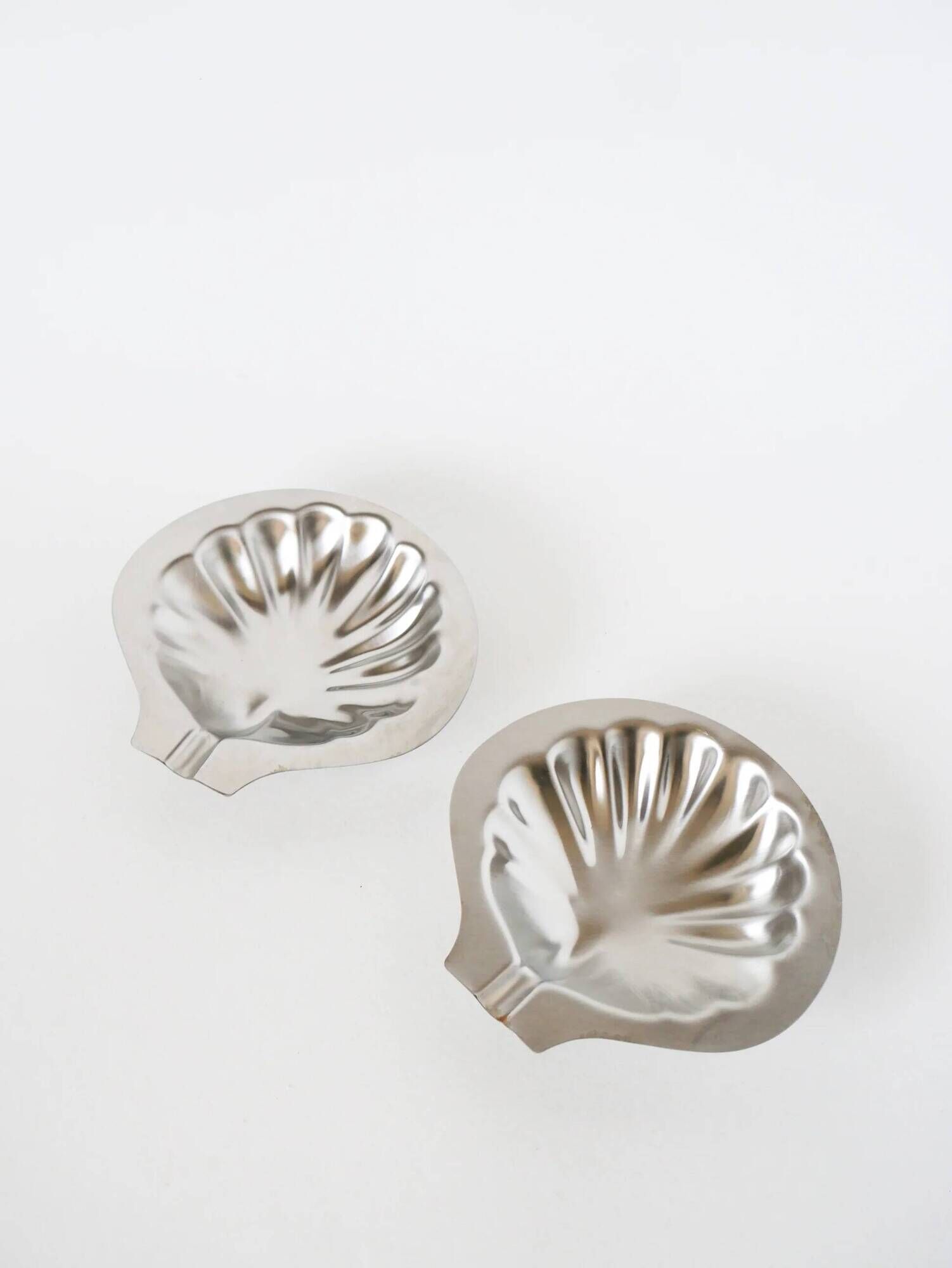 Pair of shell-shaped stainless steel catchalls, design, 1970