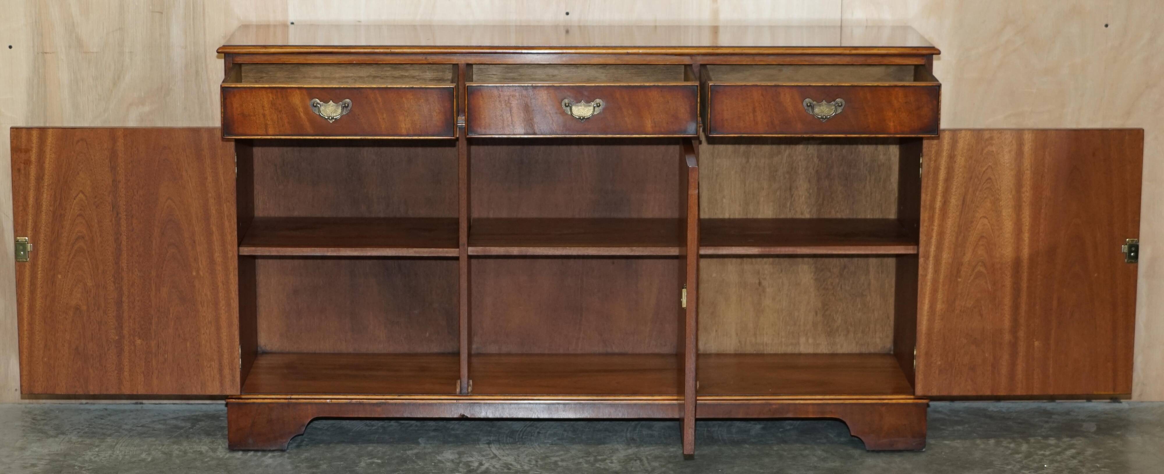 Vintage mahogany buffet with three drawers and shelves.