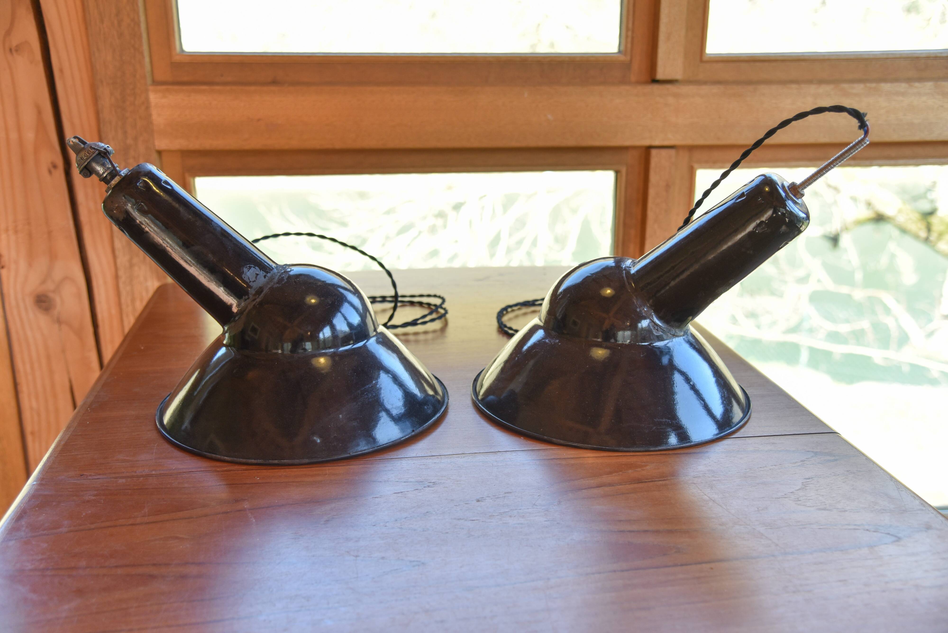 Pair of black enamelled sheet metal pendant lights from the 1950s.