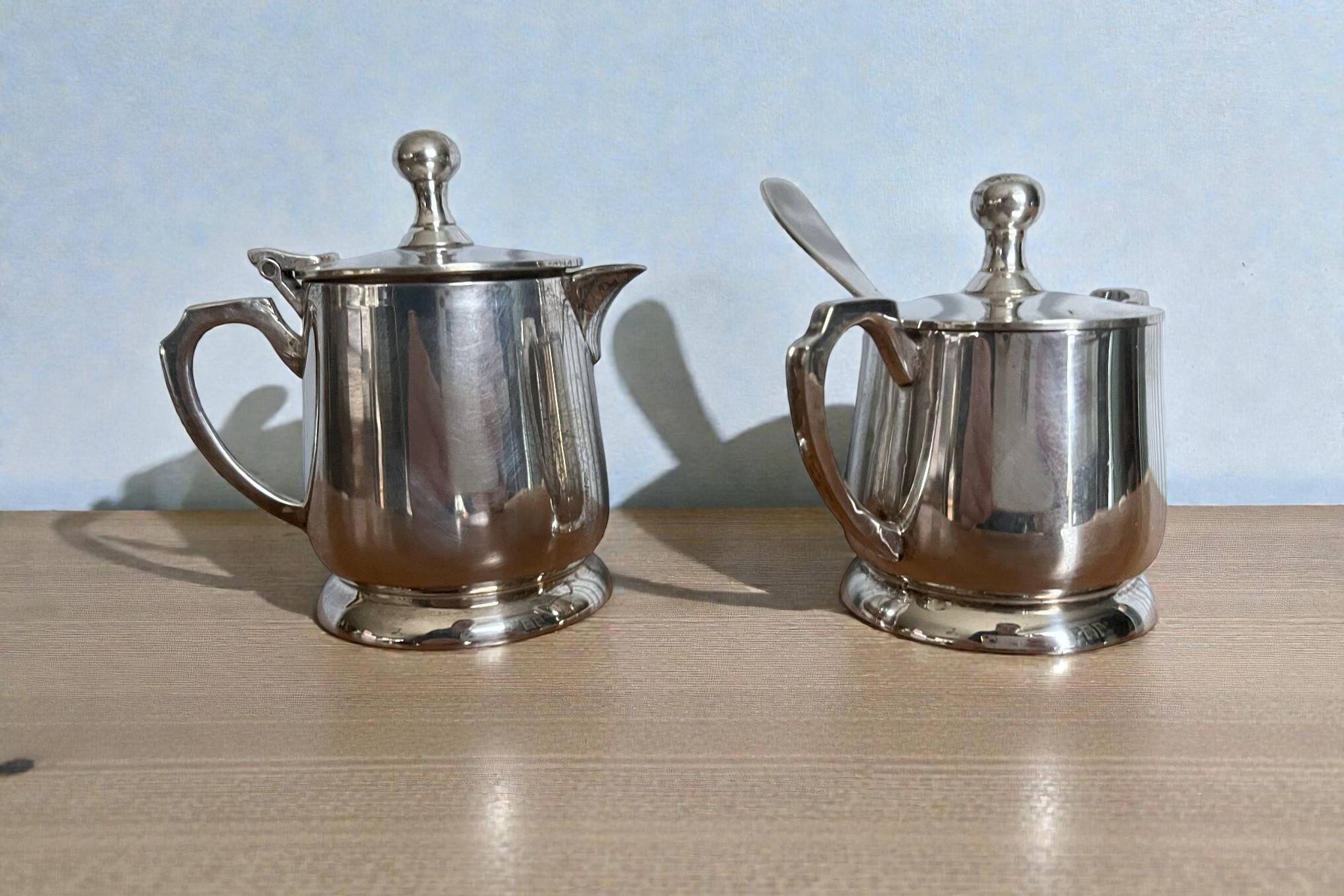 Two small silver-plated metal tea service pots from the 20th century.