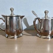 Two small silver-plated metal tea service pots from the 20th century.