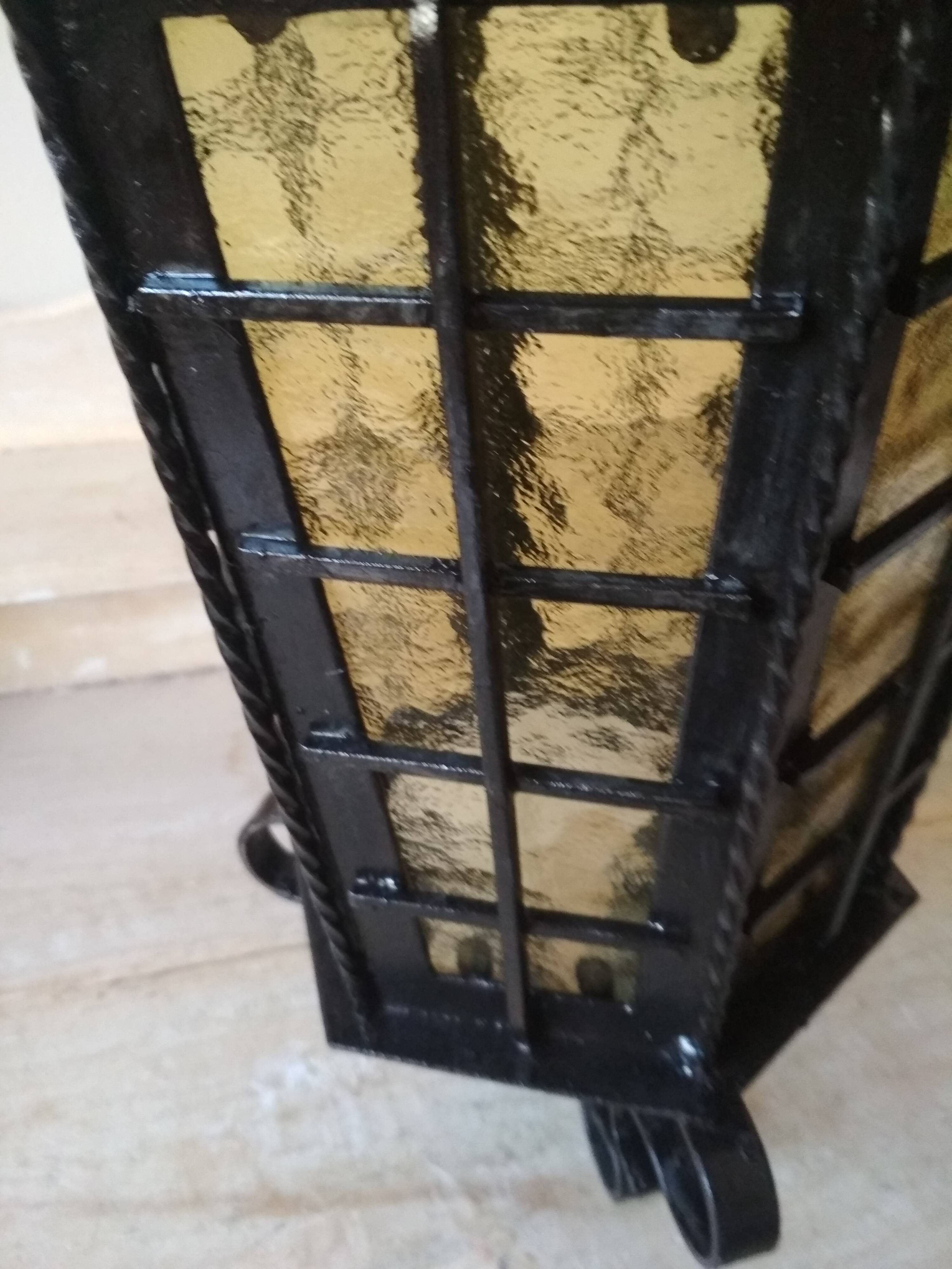 Large hanging lantern in wrought iron and opaque yellow-orange windows