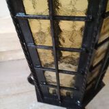 Large hanging lantern in wrought iron and opaque yellow-orange windows