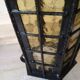 Large hanging lantern in wrought iron and opaque yellow-orange windows
