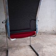 Set of 4 cantilever chairs with burgundy seat and mesh backrest.