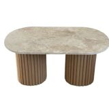 Oval coffee table in travertine and raw fluted wood.