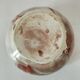 Red-orange glazed ceramic workshop bowl with floral decoration.