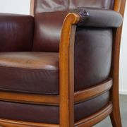 Very comfortable classic cowhide armchair with a high back in a mild Art Deco style