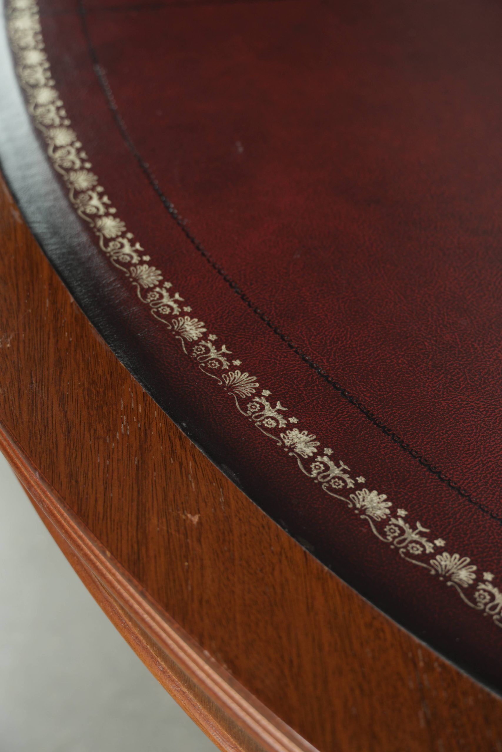 Table basse avec un plateau en cuir rouge de style anglais du 20e siècle.
