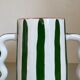 Green and white striped ceramic vase with abstract handmade corrugated handheld