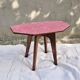Small Scandinavian side table with wood and pink tiles, with tapered legs.