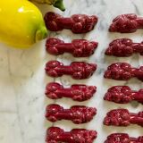 12 porte-couteaux "Dog" en céramique bordeaux - 1950.