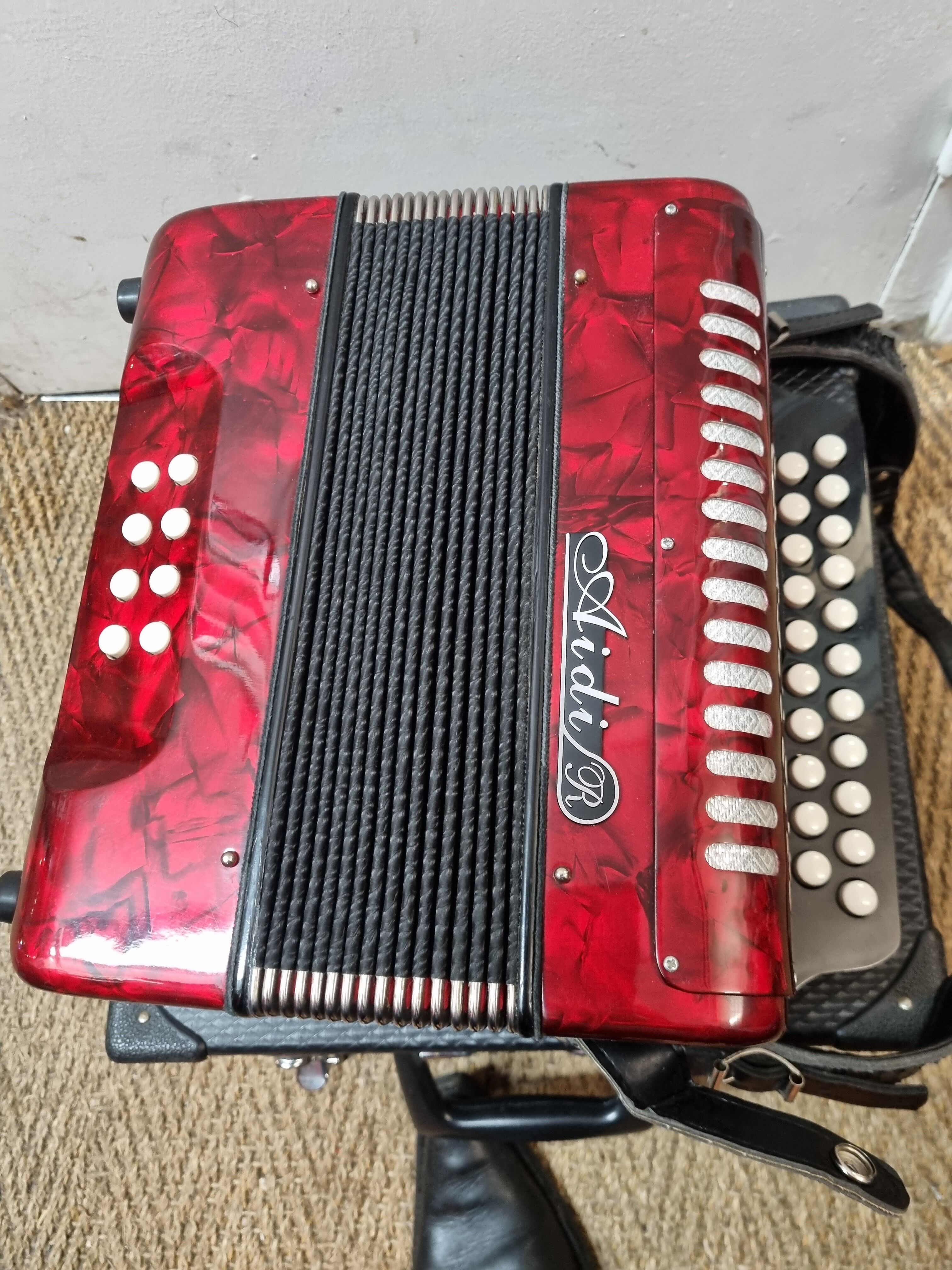 Red Aidi R accordion in his suitcase