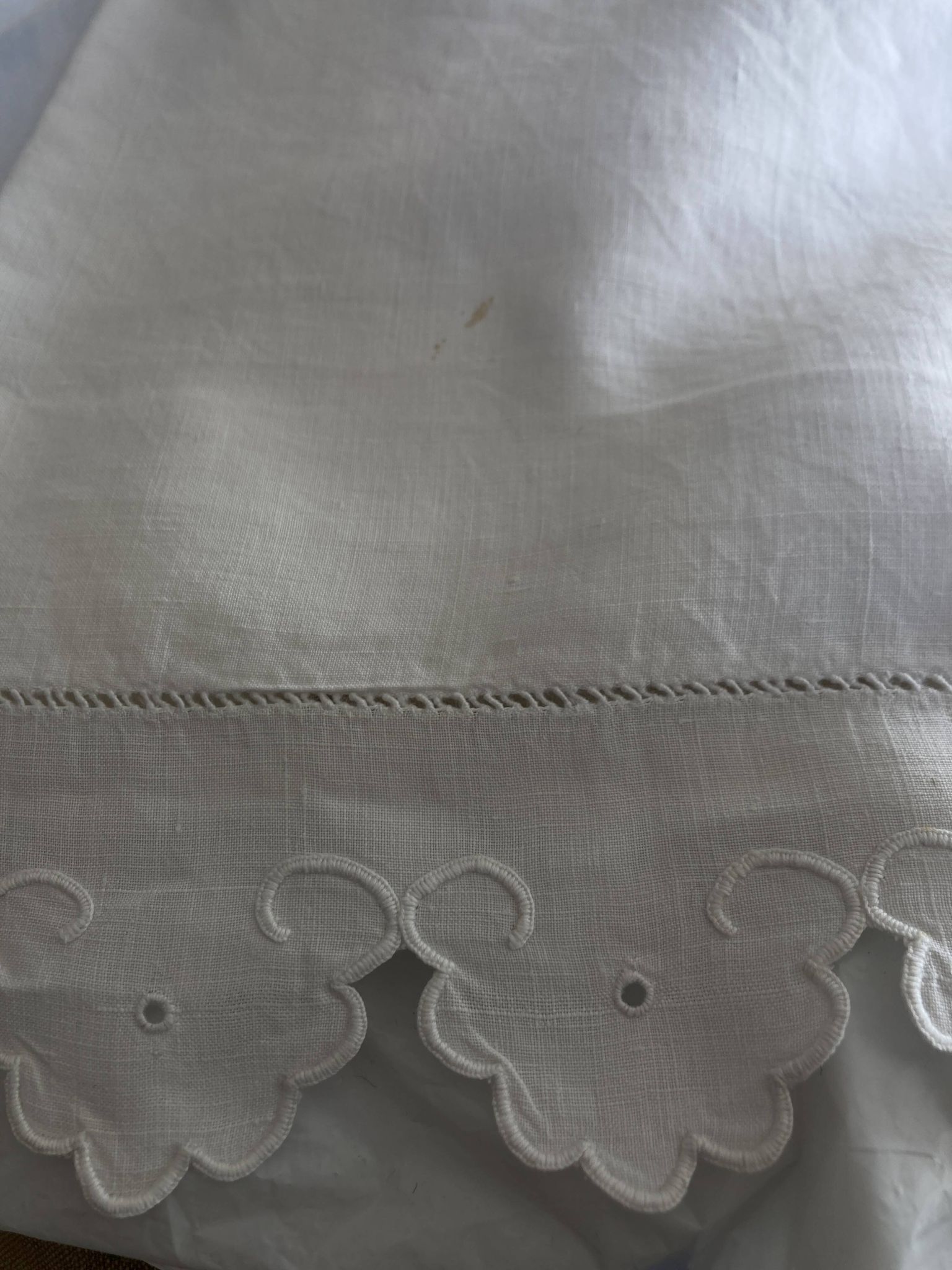 Pair of 19th-century linen pillowcases embroidered with scallops.