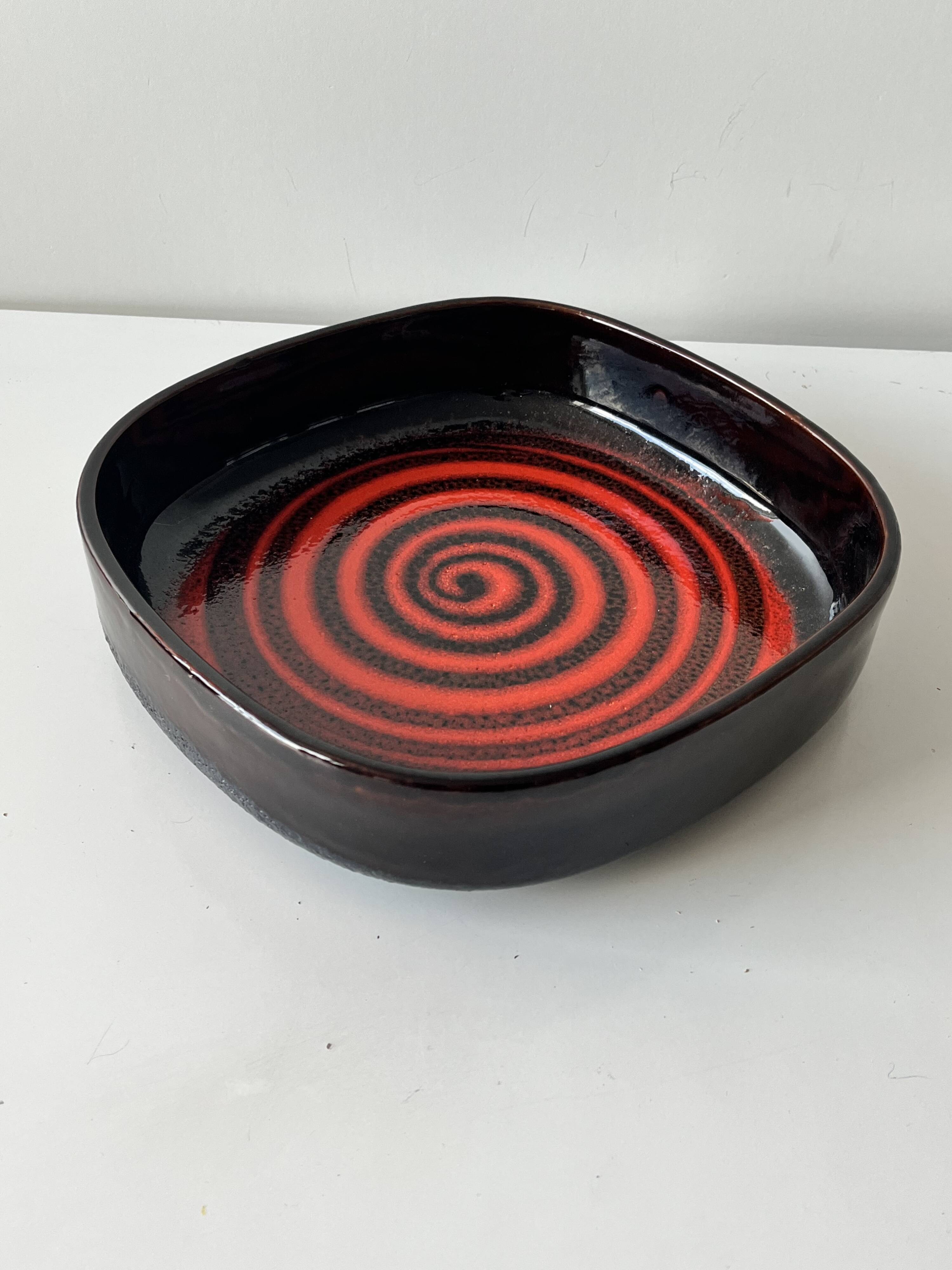 Large decorative ceramic catchall with red and black spiral pattern.