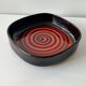 Large decorative ceramic catchall with red and black spiral pattern.