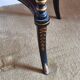 Tripod stool in blackened wood with painted floral decoration.