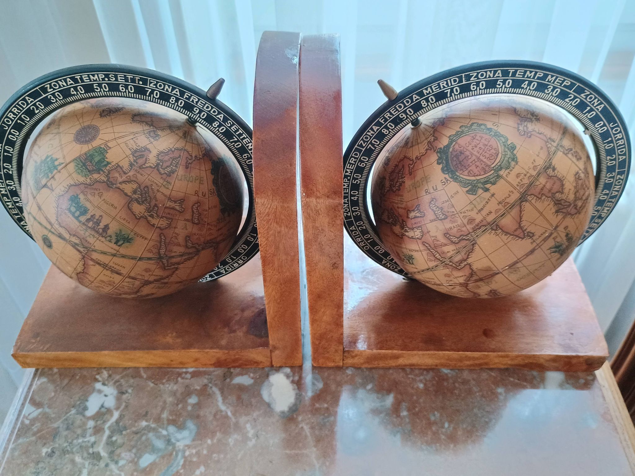 Pair of vintage bookends with rotating terrestrial globes on wooden bases in Spain
