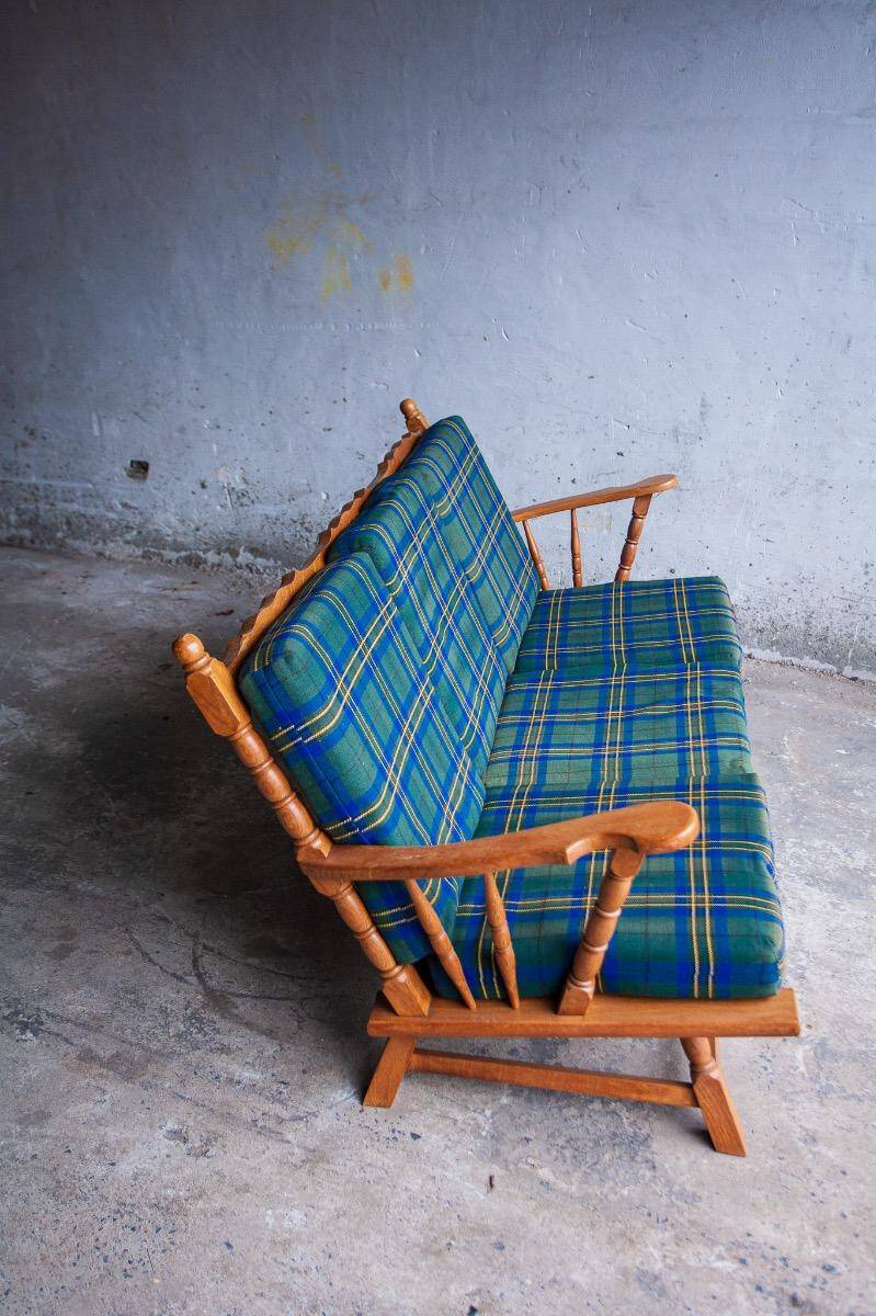 Canapé 3 places en chêne style années 50, avec tissu à carreaux vert-bleu et accoudoirs à fuseaux tournés.