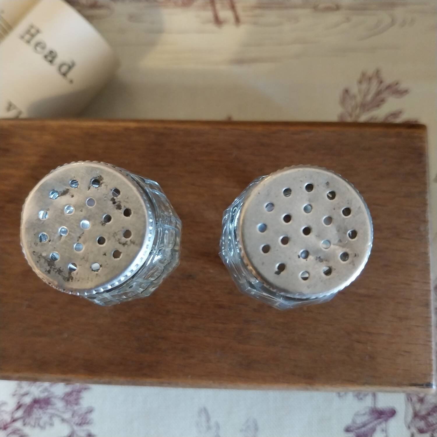 Antique salt and pepper shakers in crystal and silver metal.