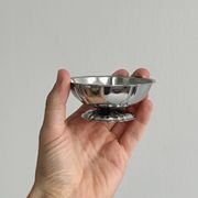 Set of 9 low bowls in shiny stainless steel.