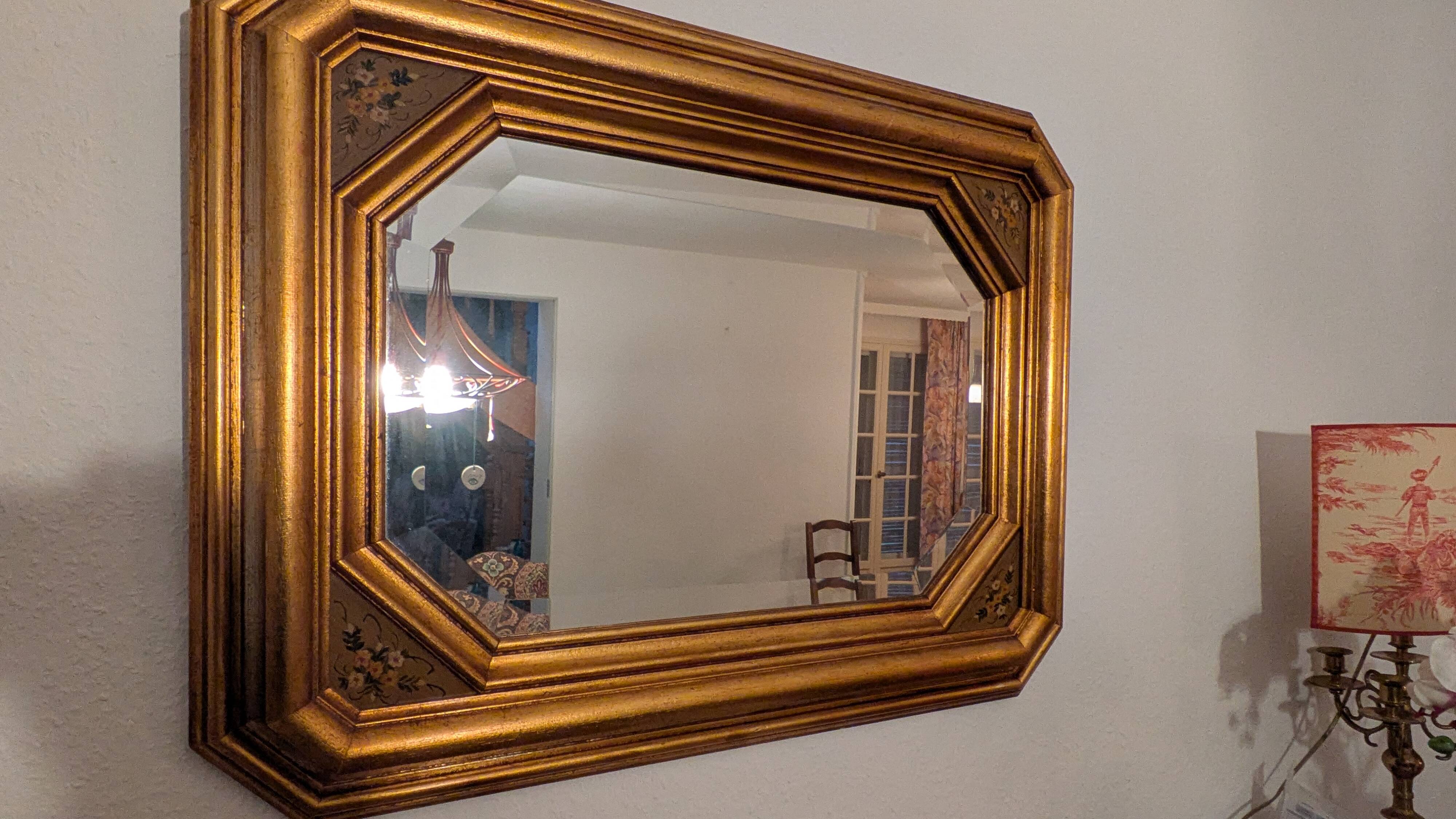 Antique octagonal mirror in gilded wood with painted floral decoration.