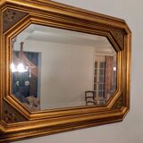 Antique octagonal mirror in gilded wood with painted floral decoration.