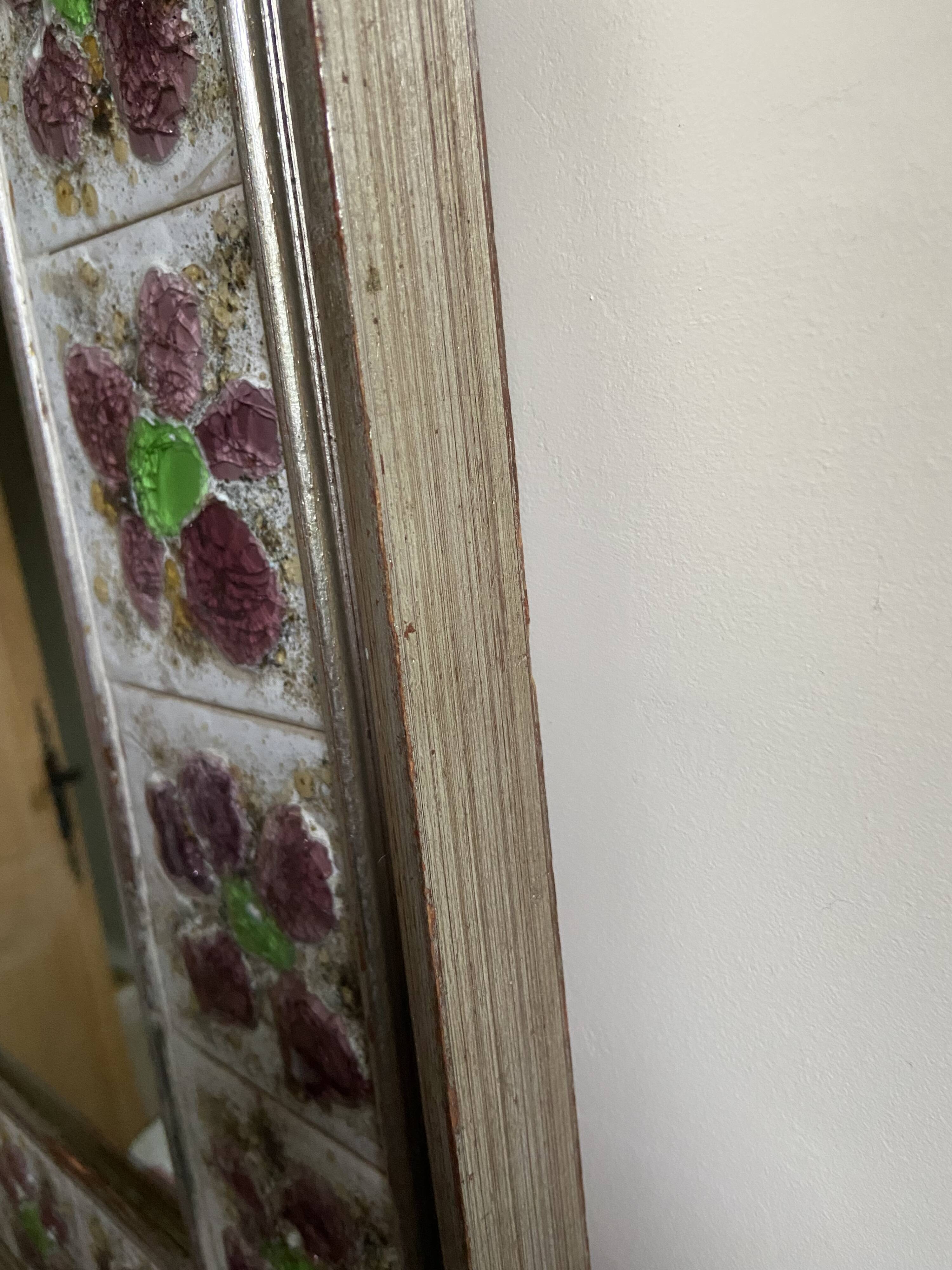 Large square ceramic mirror with floral decoration.