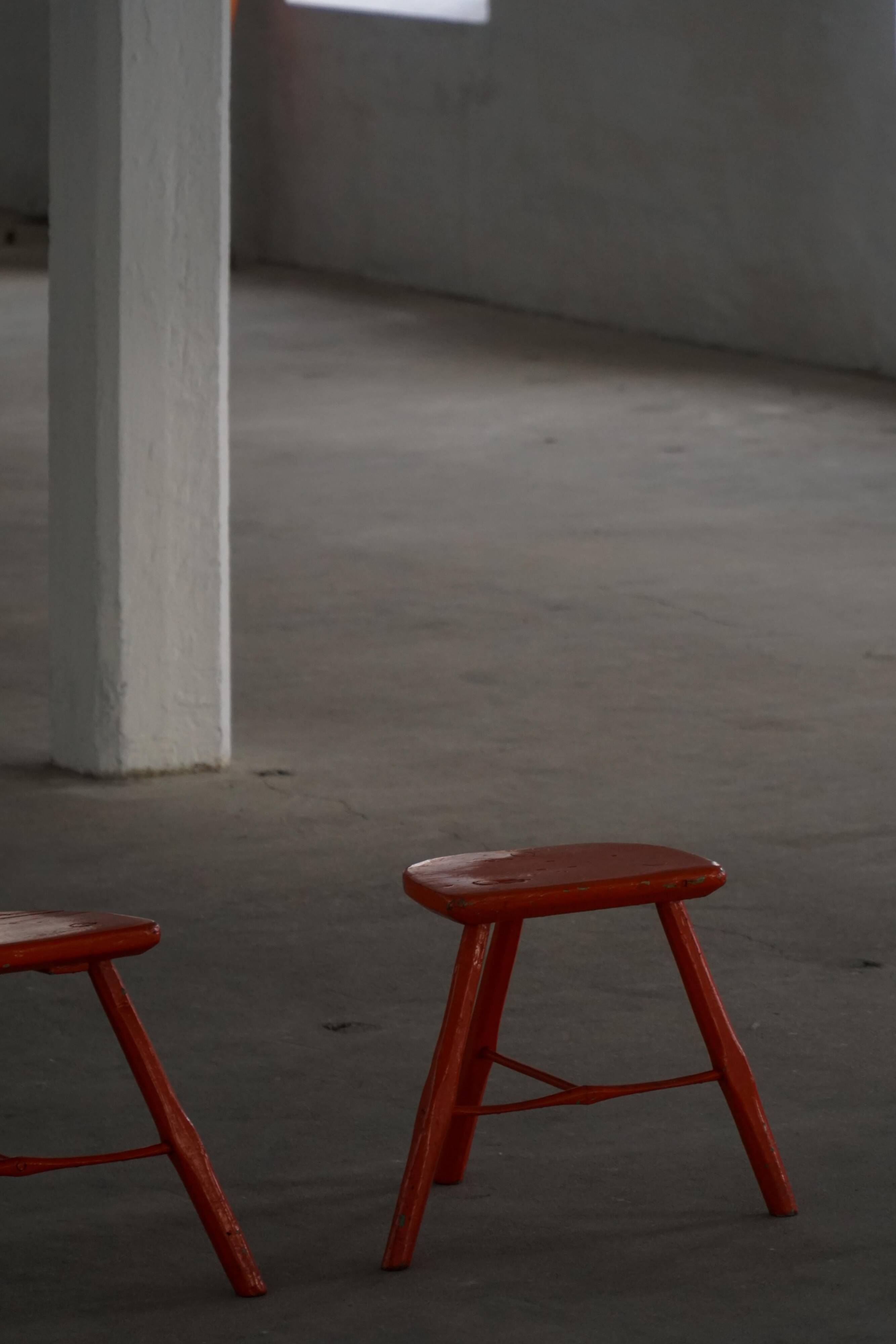 Pair of patinated wooden stools painted red with flared legs, 1950s-1960s.