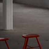 Pair of patinated wooden stools painted red with flared legs, 1950s-1960s.