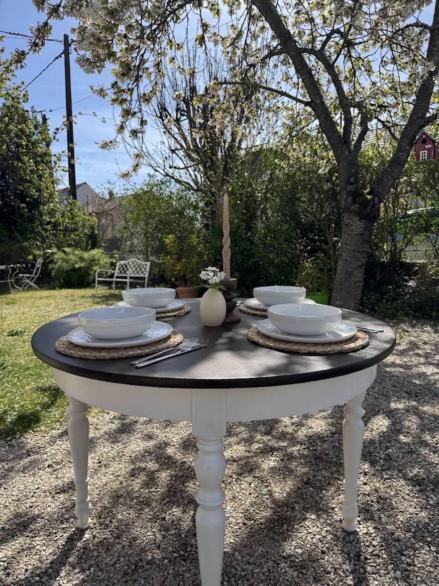 Restored solid wood round table with integrated extensions.